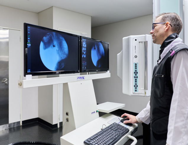 Profesional médico observando imágenes radiológicas durante un procedimiento intervencionista en el IADT