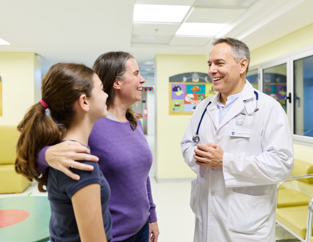 Médico pediatra conversando con una paciente y su madre en el área de consultorios externos de Pediatría del IADT