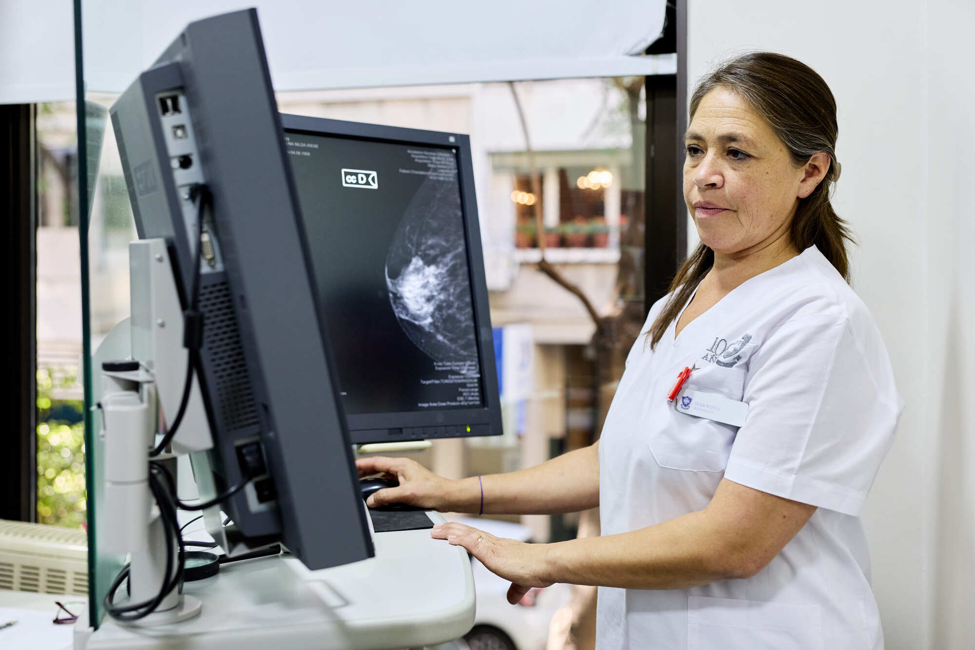Profesional analizando imágenes de mamografía digital en estación de trabajo