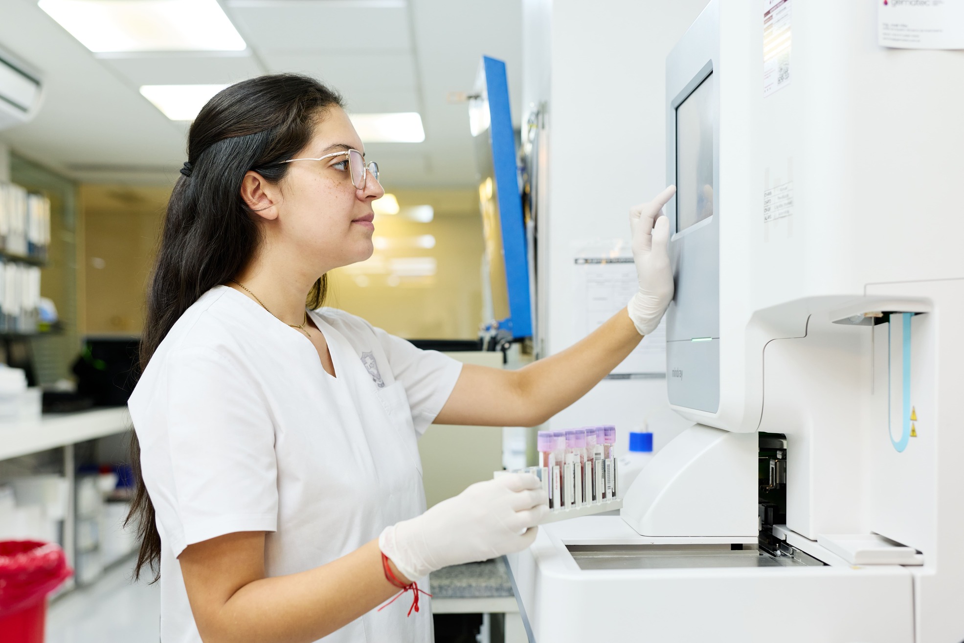 Profesional del laboratorio manipulando muestras para análisis clínicos automatizados