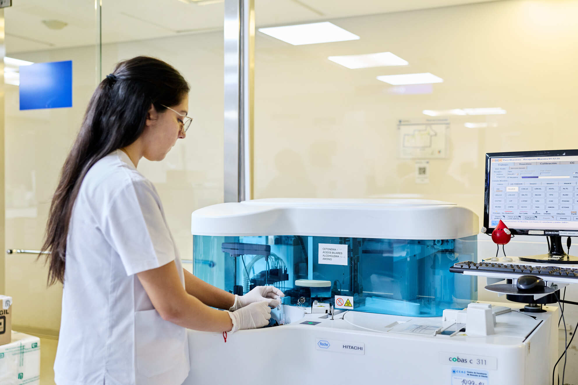 Técnica de laboratorio operando equipamiento automatizado para procesamiento de muestras