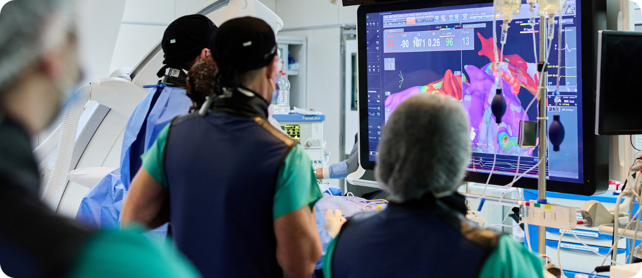 Equipo médico observando imágenes cardíacas durante un procedimiento de electrofisiología intervencionista en el IADT