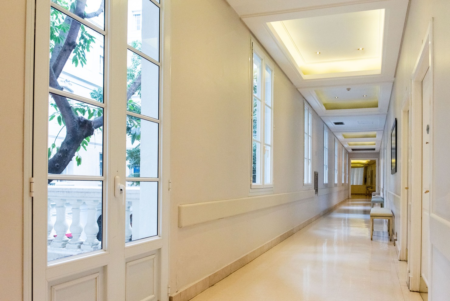 Pasillo del área de internación del IADT con iluminación natural y espacios de circulación para pacientes y acompañantes