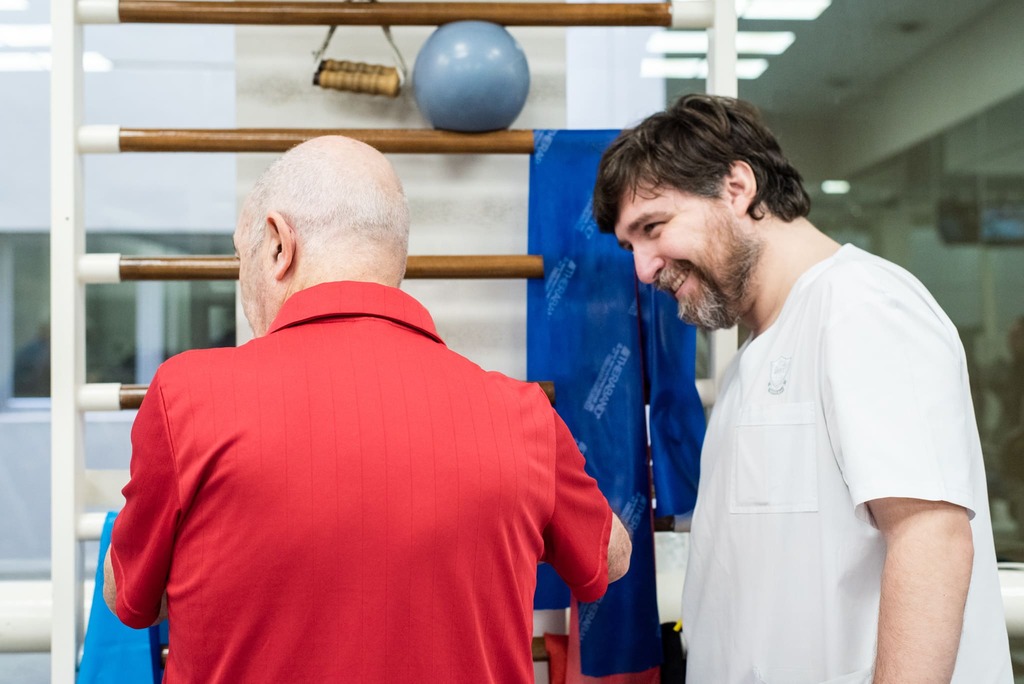 Profesional del IADT acompañando a un paciente durante una sesión de rehabilitación física