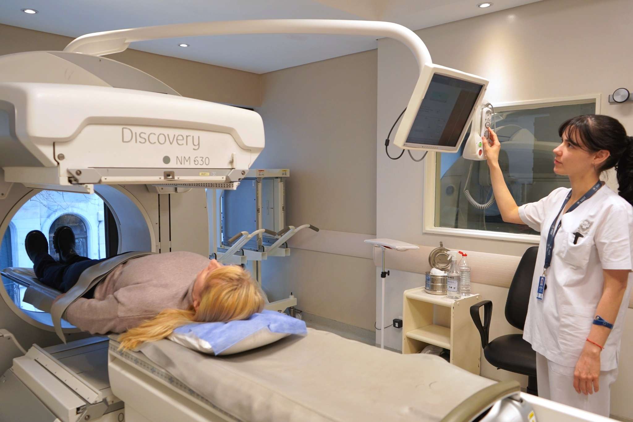 Técnica del Servicio de Medicina Nuclear del IADT preparando a una paciente para un estudio SPECT/CT.