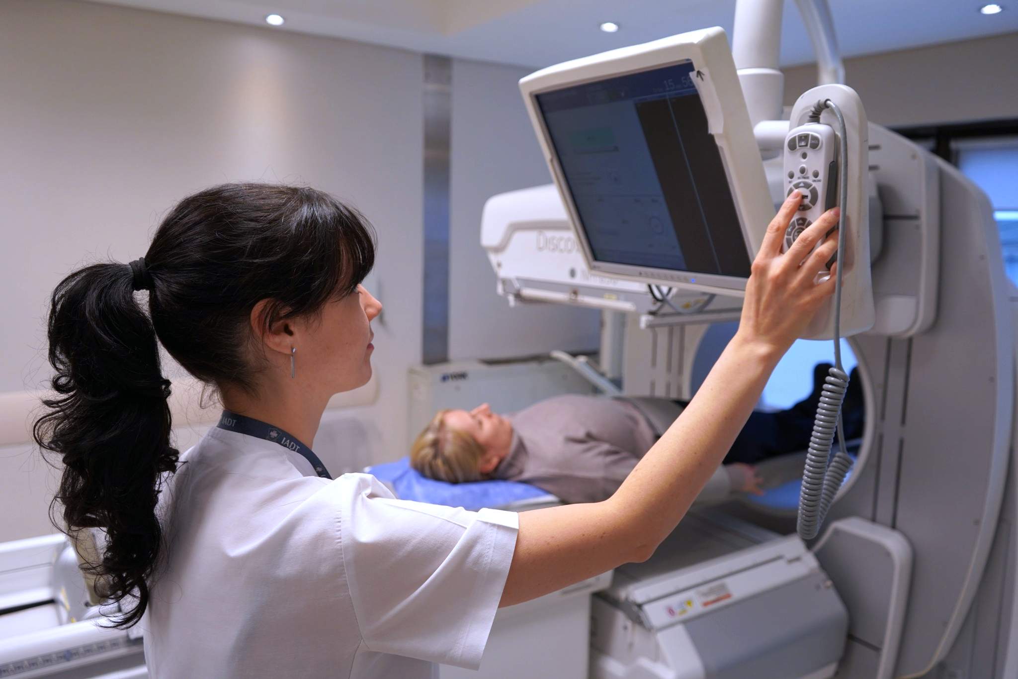 Técnica del Servicio de Medicina Nuclear del IADT preparando a una paciente para un estudio SPECT/CT.
