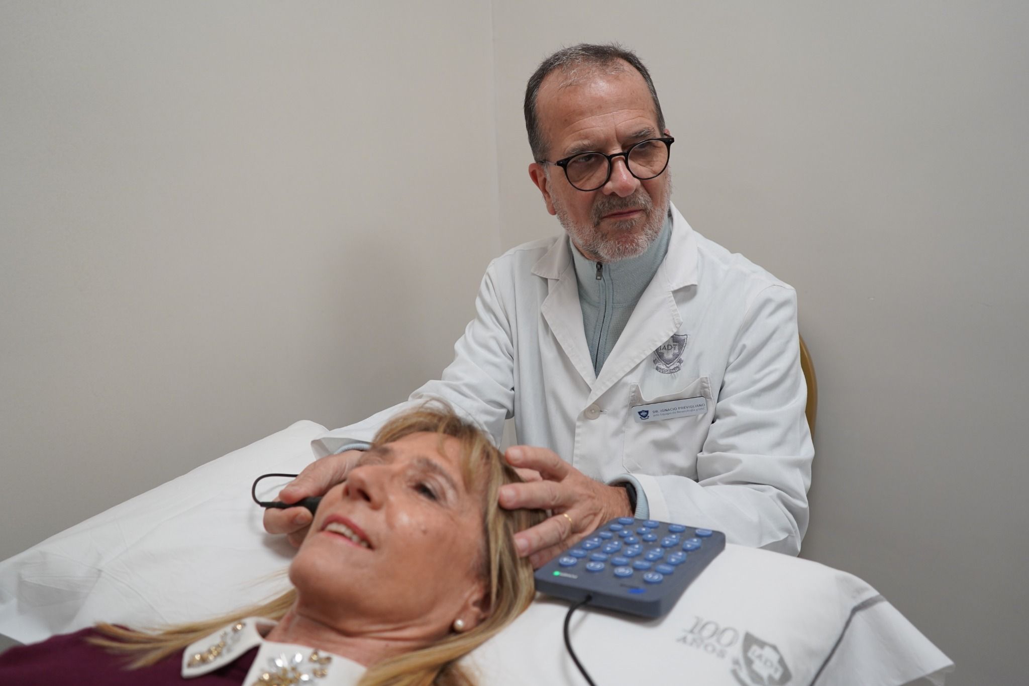 Médico neurólogo realizando una evaluación clínica neurológica a una paciente en consultorio del IADT
