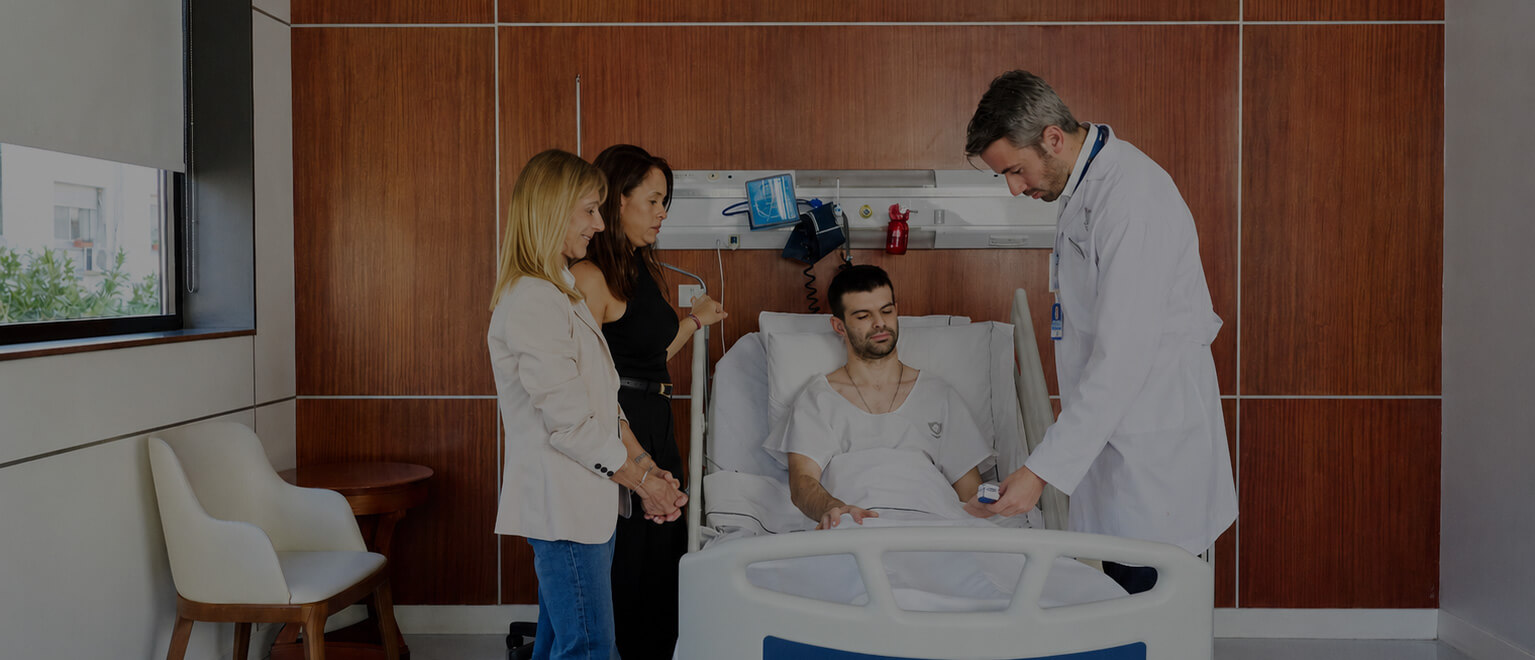 Profesional médico y equipo de salud del IADT acompañando a un paciente durante su atención en internación