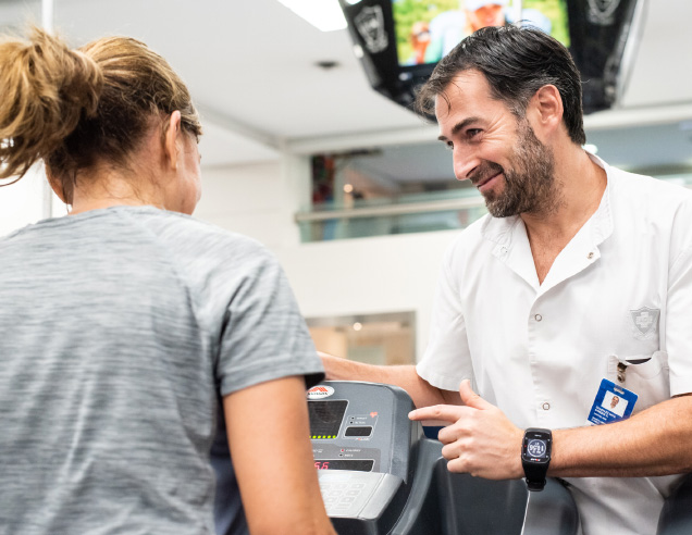 Profesional de salud acompañando a una paciente durante un entrenamiento cardiovascular supervisado